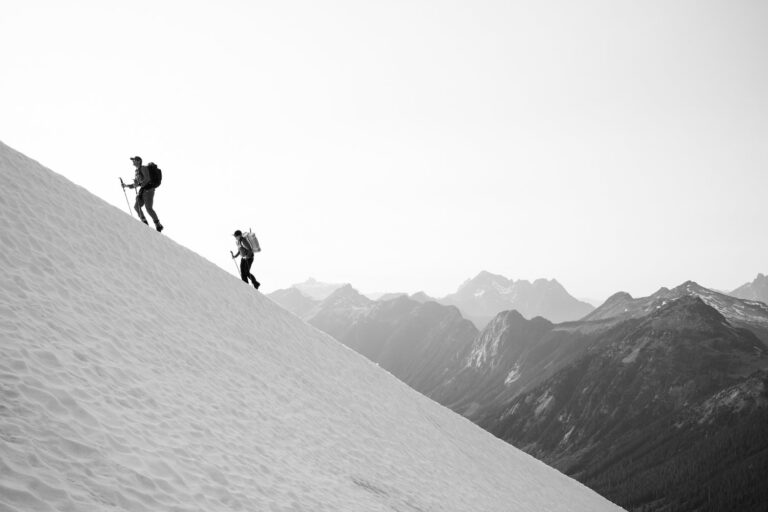 A team of climbers hike a snowy mountain side.